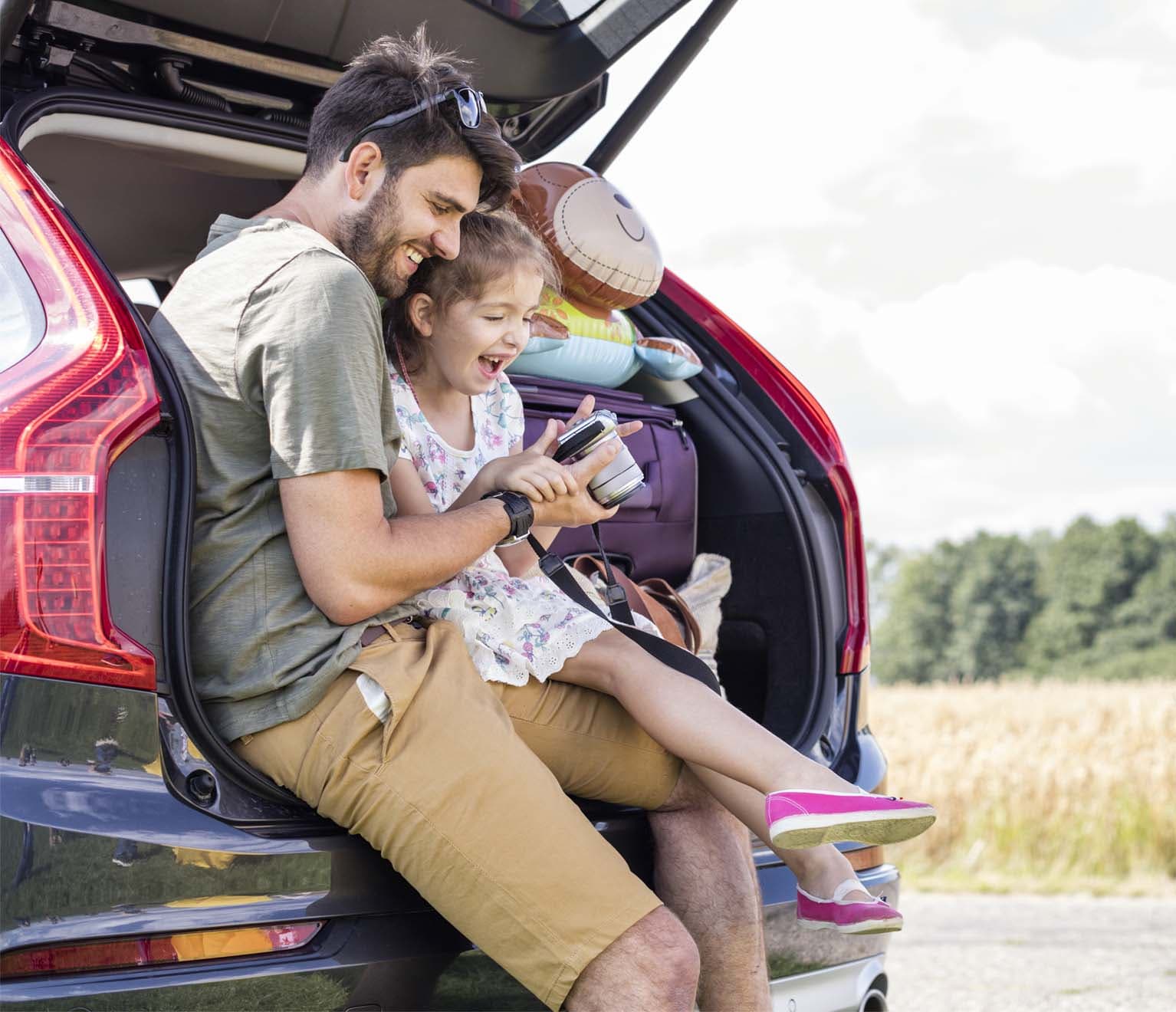 Father and daughter in back of SUV